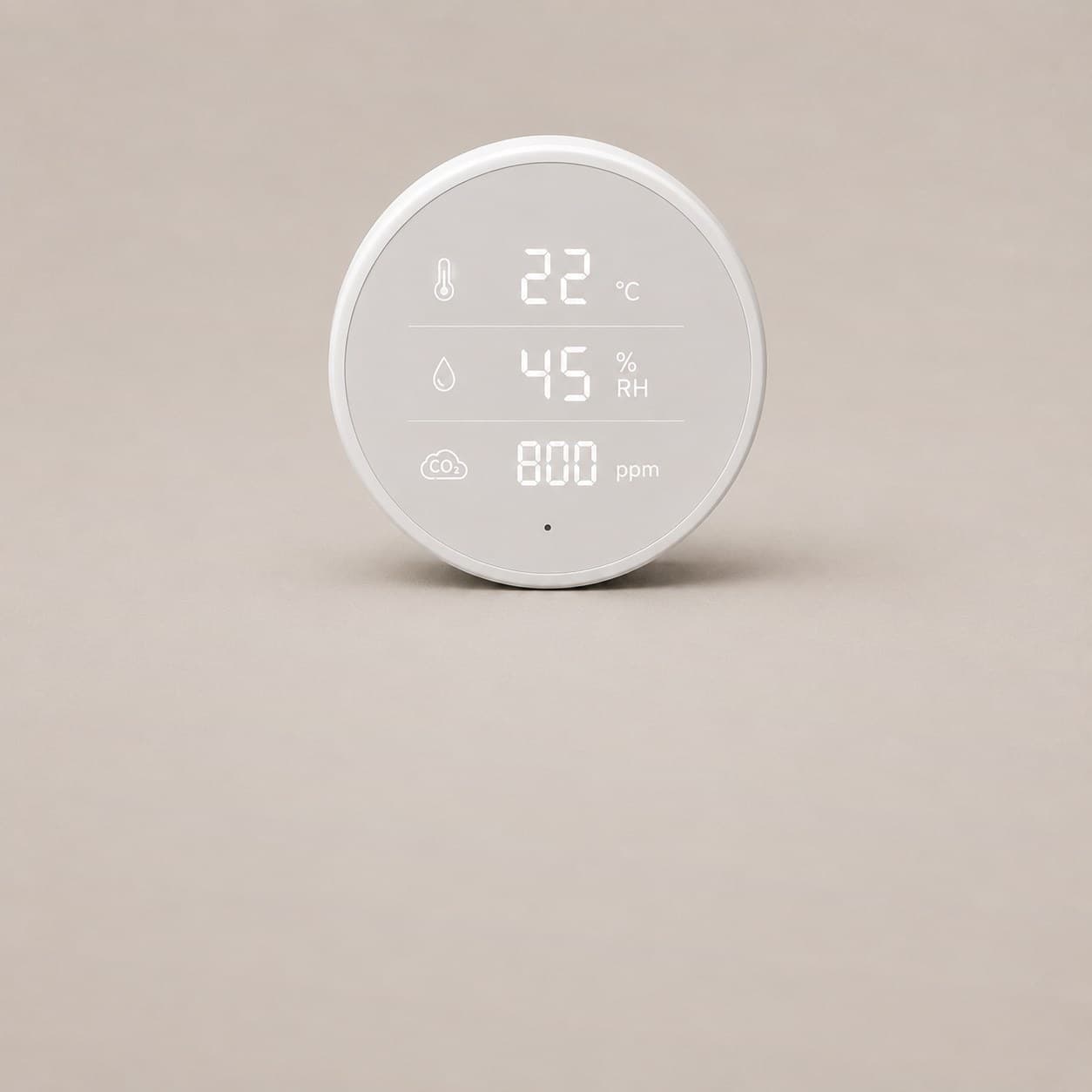 A round white room sensor, its face reading twenty two degrees, forty five percent humidity and eight hundred parts per million of carbon dioxide.